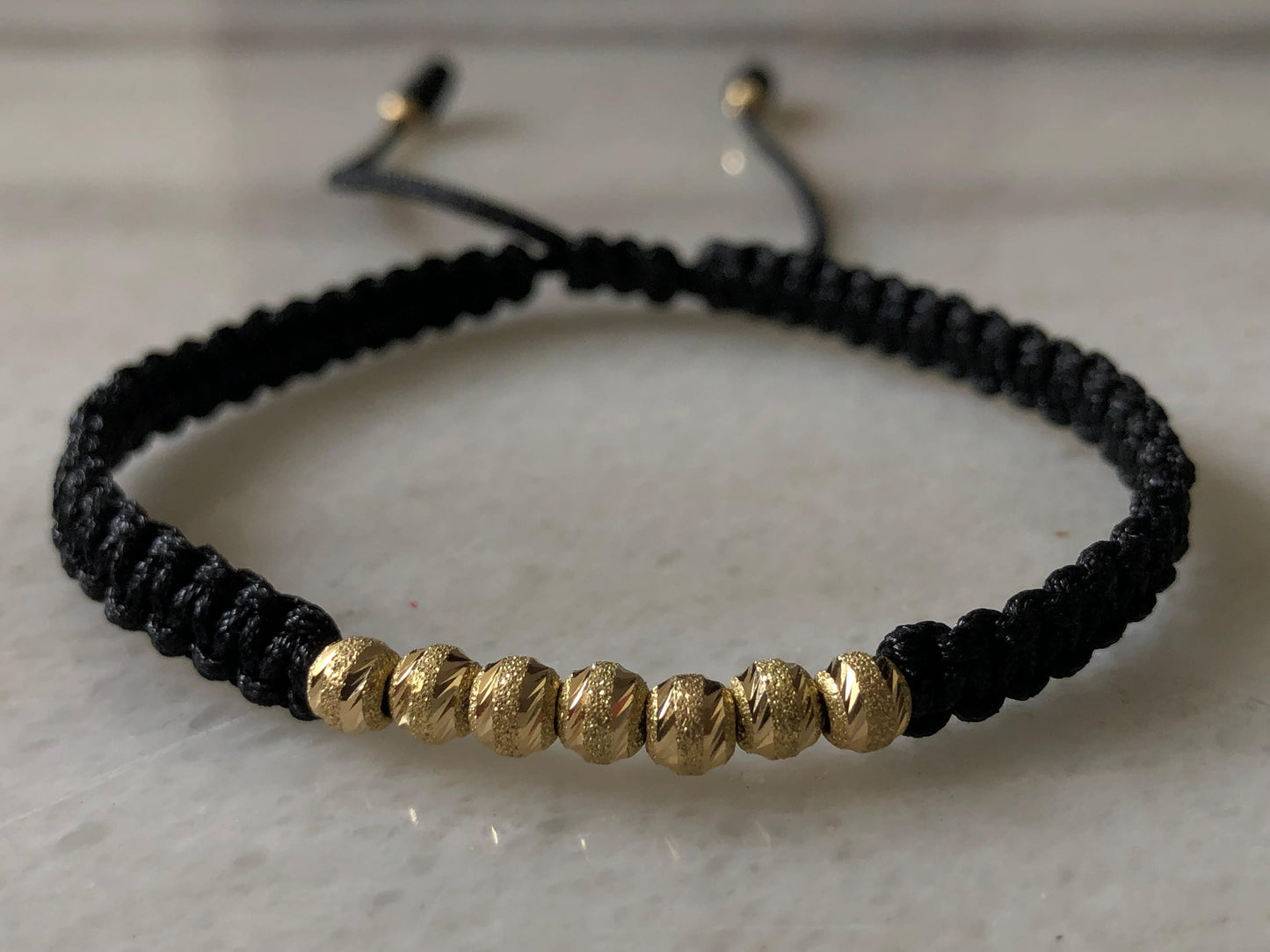 PULSERA TEJIDA EN HILO NEGRO ORO 18K