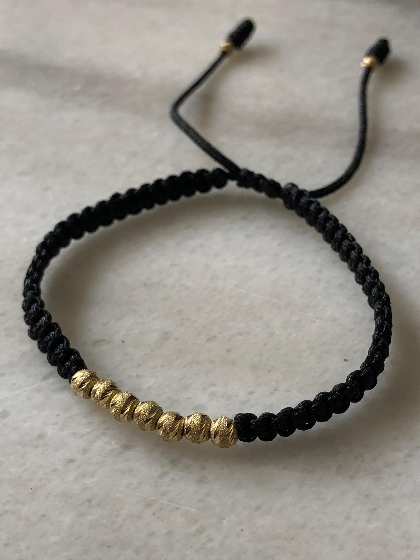 PULSERA TEJIDA EN HILO NEGRO ORO 18K