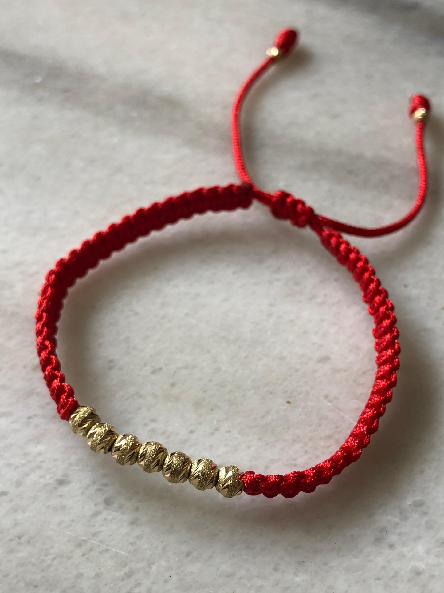 PULSERA TEJIDA EN HILO ROJO ORO 18K
