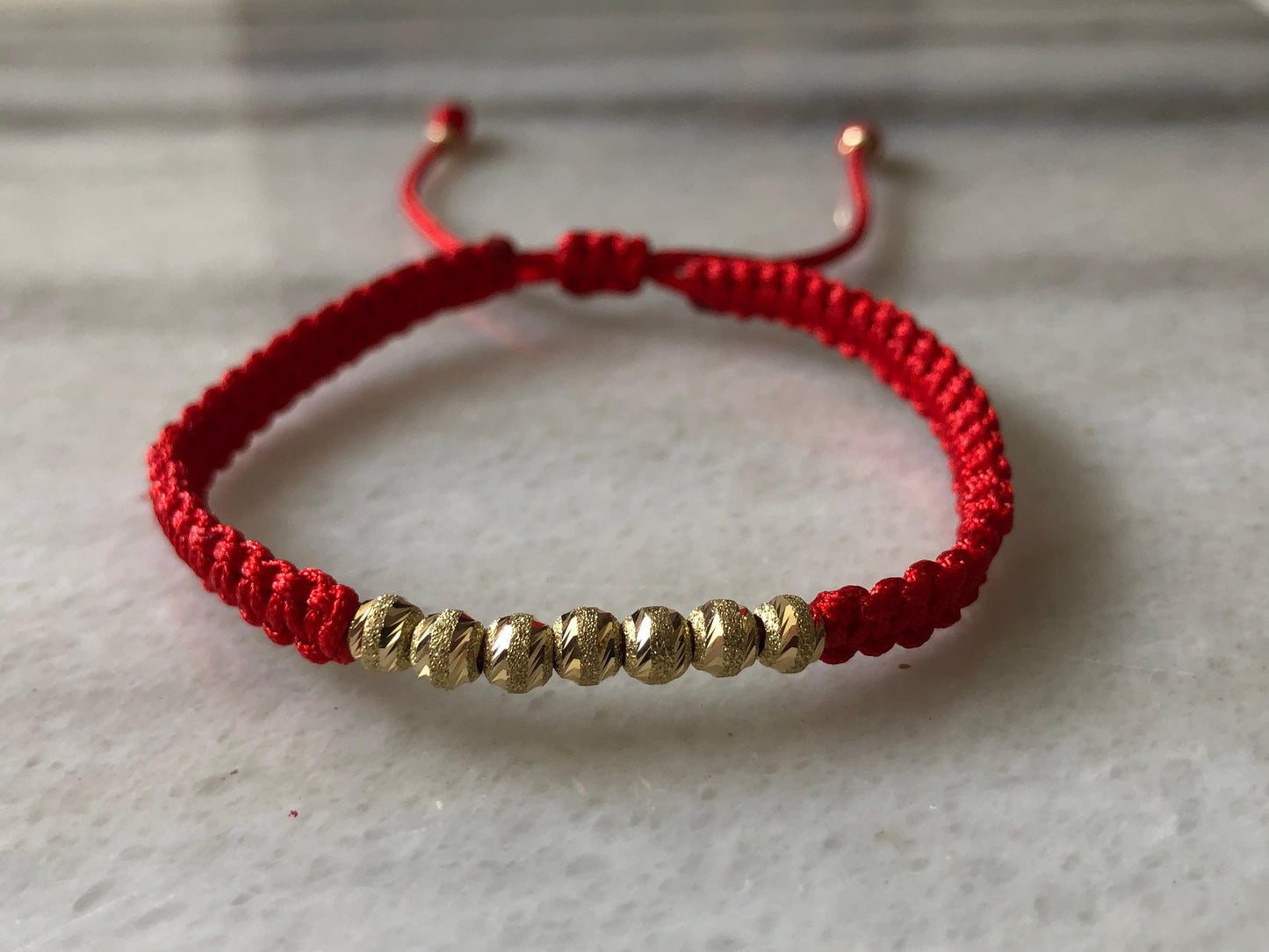 PULSERA TEJIDA EN HILO ROJO ORO 18K